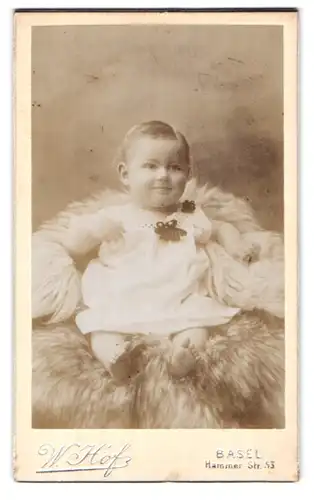 Fotografie W. Hof, Klein-Basel, Hammerstrasse 53, Portrait süsses Kleinkind im weissen Kleid mit nackigen Füssen
