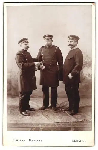 Fotografie Bruno Riedel, Leipzig, Rosenthalgasse 9, Portrait drei Beamte in Uniform mit Aktentaschen