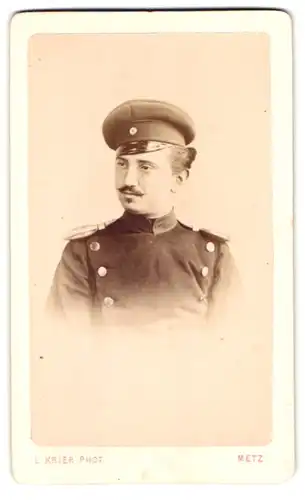 Fotografie L. Krier, Metz, Rue des Clerce 11, Portrait Soldat in Uniform mit Epauletten und Mütze