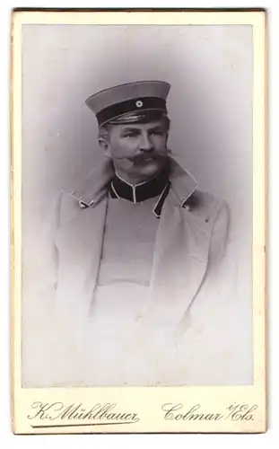 Fotografie K. Mühlbauer, Colmar i. Els., Stanislaus-Str. 10, Portrait Soldat in Uniform mit Mantel und Zwirbelbart