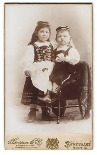 Fotografie Samson & Co., Stuttgart, Poststr. 5, Portrait Kinder in Trachtenkleidung mut Mütze