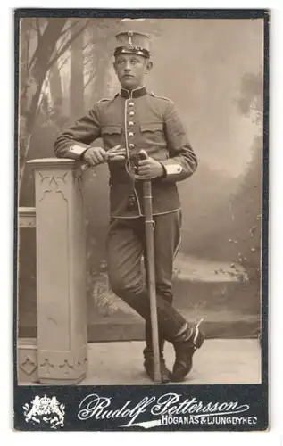 Fotografie Rudolf Pettersson, Höganäs, Portrait junger Soldat in Uniform Rgt. 1 mit Säbel