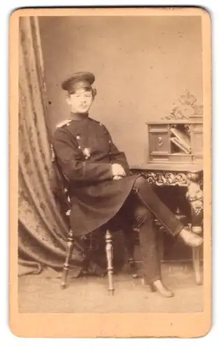 Fotografie W. Köppelmann, Paderborn, Eisenbahn-Str. 960, Portrait Soldat im Waffenrock sitzt am Sekretär