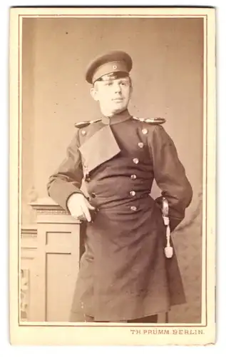 Fotografie Th. Prümm, Berlin, Unter den Linden 51, Portrait Soldat in Uniformrock mit Epauletten und Säbel