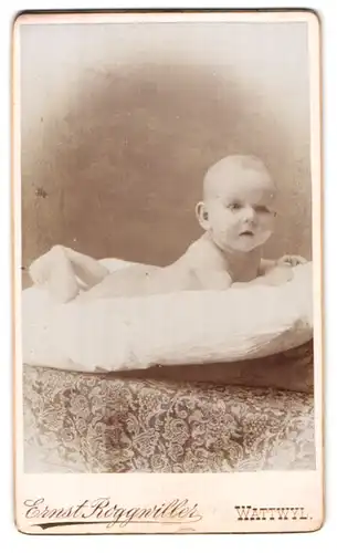 Fotografie Ernst Roggwiller, Wattwyl, niedliches Baby auf Kissen liegend