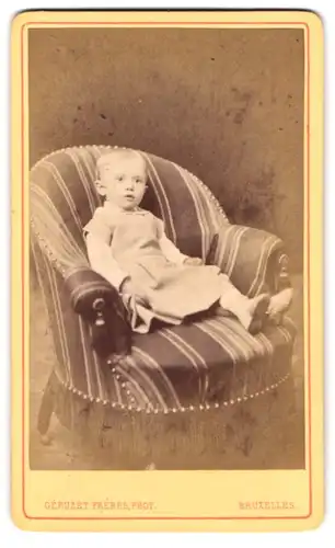Fotografie Géruzet Frères, Bruxelles, 27 Rue de l`Ecuyer, entspanntes Kleinkind auf Sessel liegend