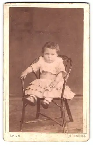 Fotografie J. Grimm, Offenburg, verschrecktes kleines Kind in Stuhl lehnend
