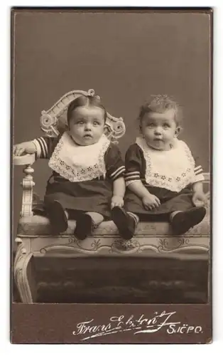 Fotografie Frans Ekdahl, Sjöbo, Portrait zwei Kleinkindern in Kleidern mit Sabberlatz