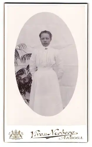 Fotografie Vivan Norberg, Arboga, Portrait junge Frau im weissen Kleid mit Kreuzbrosche