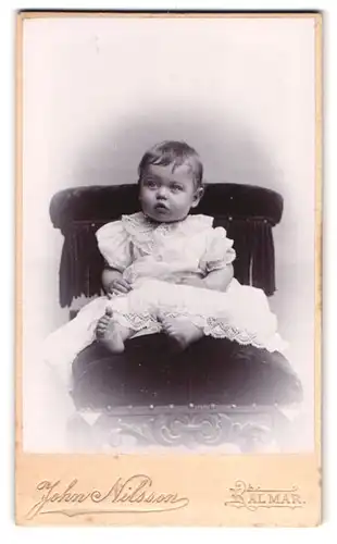 Fotografie John Nilsson, Kalmar, Portrait Kleinkind im weissen Kleid sitzt auf einem Stuhl