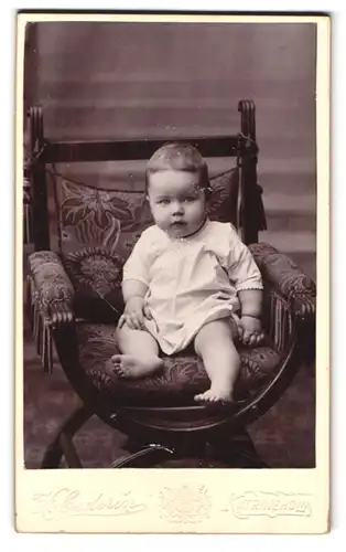 Fotografie H. Cederin, Katrineholm, Portrait Kleinkind im weissen Leibchen auf einen Stuhl sitzend