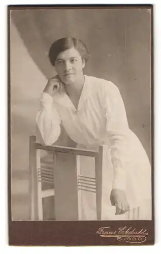 Fotografie Franz Ekdahl, Sjöbo, Portrait Dame im weissen Kleid auf Stuhl gelehnt