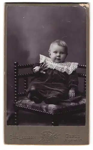 Fotografie Carl Larsson, Gefle, Nygatan 34, Portrait Kleinkind im Kleid mit Rüschenkragen winkt in die Kamera