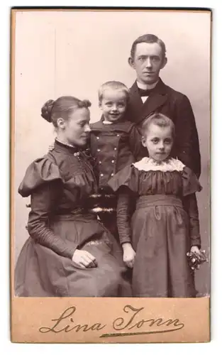 Fotografie Lina Jonn, Lund, Bantorget 6, Portrait junge Familie mit zwei Kindern im Kleid und Anzug posieren im Atelier
