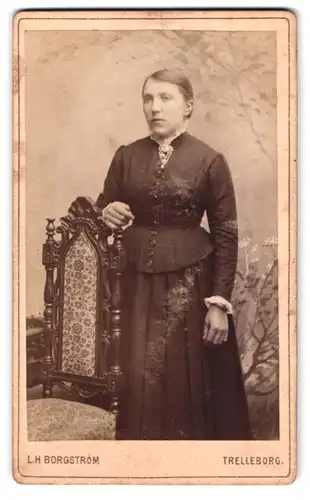 Fotografie L. H. Borgström, Trelleborg, Portrait Dame im Biedermeierkleid an einem Stuhl stehend