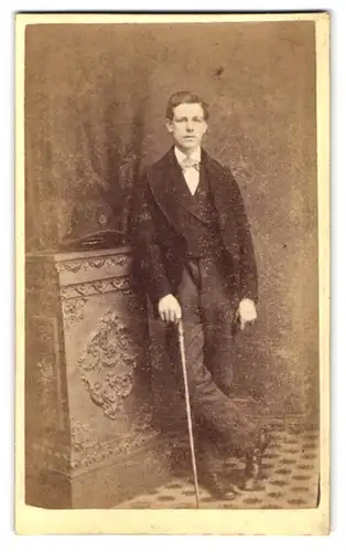 Fotografie Fotograf und Ort unbekannt, Portrait junger Mann im Anzug mit Spazierstock
