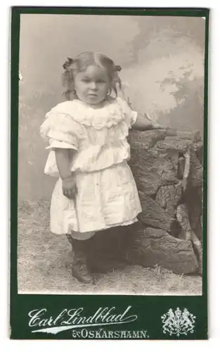 Fotografie Carl Lindblad, Oskarshamn, Portrait kleines Mädchen im weissen Kleid mit Zöpfen