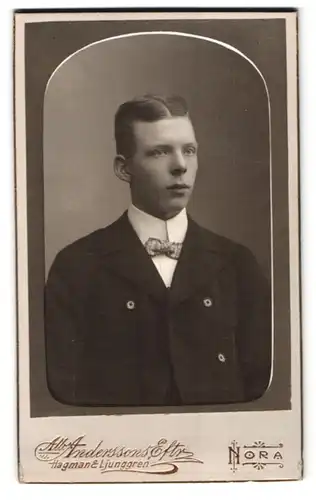Fotografie Alb. Anderssons, Nora, Portrait junger Mann im schwarzen Anzug mit karierter Fliege