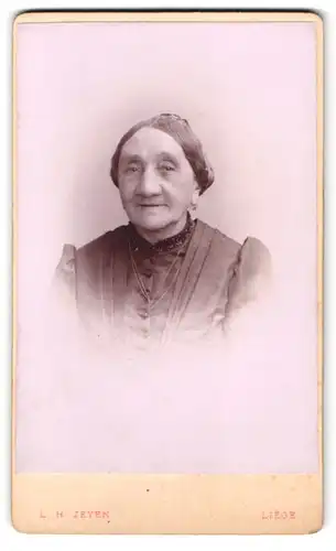 Fotografie L. H. Zeyen, Liege, Portrait alte Frau im Kleid mit Puffärmeln
