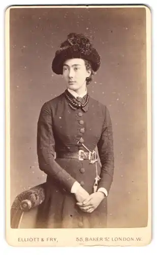 Fotografie Elliot & Fry, London, Baker St. 55, Portrait hübsche junge Frau im schicken Kleid mit Hut