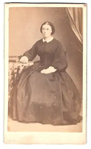 Fotografie Ch. Domergue, Agen, Rue Garonne 31, Portrait Frau im schwarzen Kleid sitz an einem Tisch