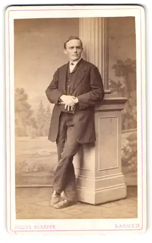 Fotografie Julius Schäfer, Barmen, Herr im Anzug an Säule lehnend