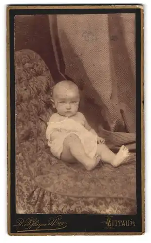Fotografie R. Pflüger, Zittau, Baby im weissen Hemdchen auf Sessel sitzend