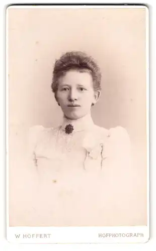 Fotografie W. Höffert, Hannover, Georgstr. 8, Portrait schlanke Dame im weissen Kleid mit Brosche