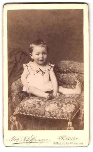 Fotografie Alph. Scheffermeyer, Malines, 40 Rue de la chaussee, niedliches Kind auf Sofa sitzend