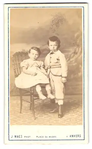 Fotografie J. Maes, Anvers, Place du Musee, Knabe nebst Mädchen im Kleid auf Stuhl sitzend