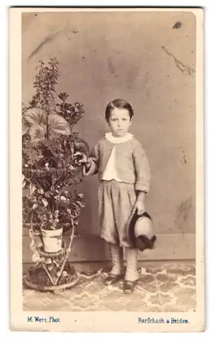 Fotografie M. Werz, Rorschach, Kind wohl gekleidet mit Hut im Foto-Atelier