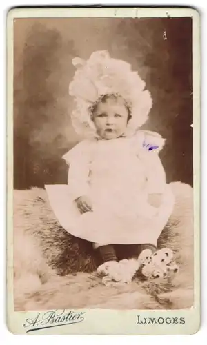 Fotografie A. Bastier, Limoges, 33 Boul. d Louis Blanc, Baby mit Haube im Taufkleid
