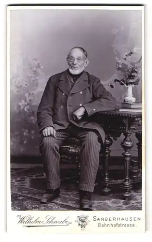 Fotografie Wilhelm Schwabe, Sangerhausen, Bahnhofstr., Portrait alter Mann im Anzug mit gestreifter Hose und Brille