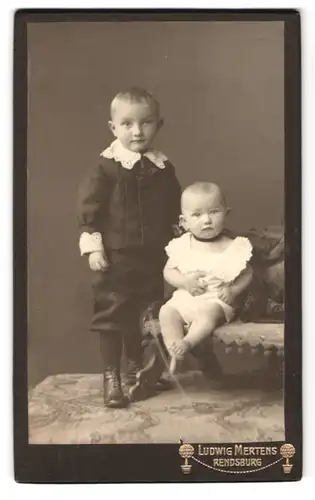 Fotografie Ludwig Mertens, Rendsburg, Am Gymnasium, Portrait zwei kleine Kinder im Anzug und Kleid