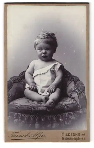 Fotografie Friedrich Alfeis, Hildesheim, Bahnhofsplatz 5, Portrait kleines Kind im weissen Leibchen auf einem Sessel