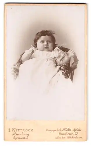 Fotografie H. Wittstock, Hamburg, Speersort 5, Portrait Kleinkind im weissen Kleid liegt im Stuhl