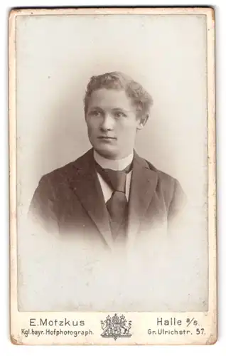 Fotografie E. Motzkus, Halle a. S., Gr. Ulrichstr. 57, Portrait junger Mann im Anzug mit Krawatte und Locken