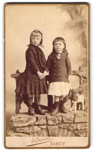 Fotografie J. Caron, Nancy, Cours Leopold 32, Portrait zwei Schwestern in Kleidern mit Spielzeugpferd