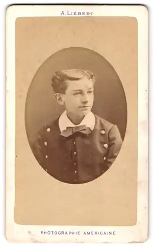 Fotografie A. Liebert, Paris, Rue de Londres 6, Portrait junger Knabe im Anzug mit Fliege und Mittelscheitel