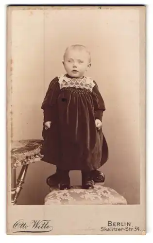 Fotografie Otto Witte, Berlin, Skalitzer-Strasse 54, Niedliches Kind im schwarzen Sonntagsanzug stehend auf dem Stuhl