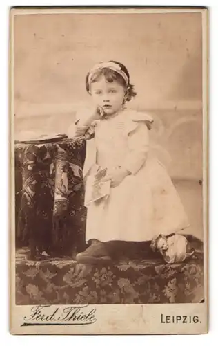 Fotografie Ferd. Thiel, Leipzig, Hospital-Str. 7, Portrait kleines Mädchen im weissen kleid mit Haarschleife
