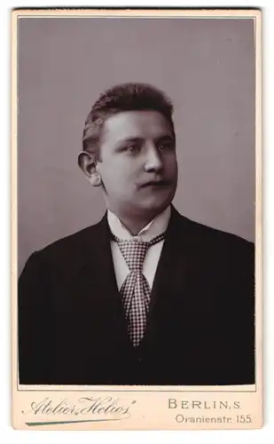 Fotografie Atelier Helios, Berlin, Oranienstr. 155, Portrait Mann im schwarzen Sacko mit kariertem Schlips