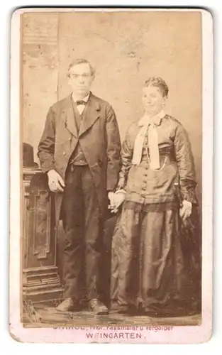 Fotografie G. Hage, Weingarten, Portrait älteres Ehepaar im Biedermeierkleid mit Schleife und Anzug mit Fliege