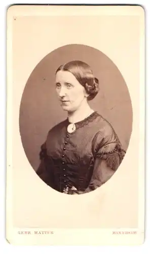 Fotografie Gebr. Matter, Mannheim, Heidelbergerstr. 59, Portrait ältere Dame im Biedermeierkleid mit Brosche, Zopf