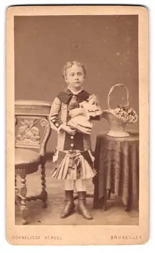 Fotografie Cornelisse Hergel, Bruxelles, 22, Rue Neuve, Portrait hübsch gekleidetes Mädchen mit einer Puppe