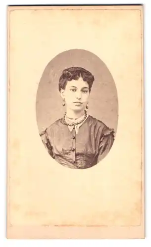 Fotografie Fotograf und Ort unbekannt, Portrait junge Frau im Kleid mit Perlenkette und Zopf