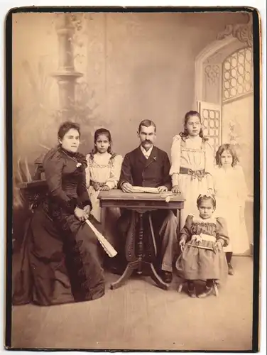 Fotografie Fotograf und Ort unbekannt, Portrait Theophil Eppen mit Familie im Atelier vor einer Studiokulisse