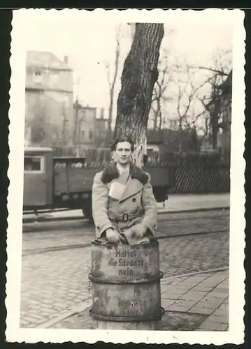 Fotografie junger Mann in Mülltonne sitzend, Aufschrift: Haltet die Strasse rein, Berlin 1948