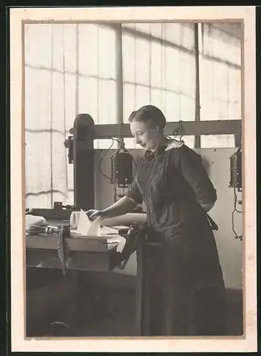 Fotografie Graphische Werkstatt, Dame sortiert Dokumente am Zeichentisch