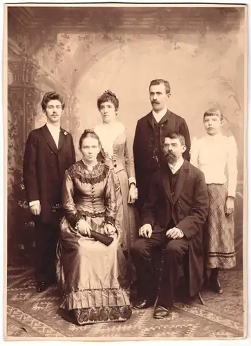 Fotografie Fr. Richter, Ort unbekannt, Portrait Familie in zeitgenössischer Kleidung vor einer Studiokulisse